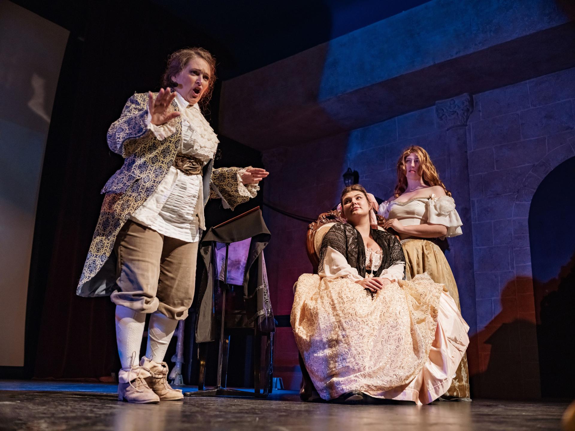 Three Actresses in period costumes on theatre stage